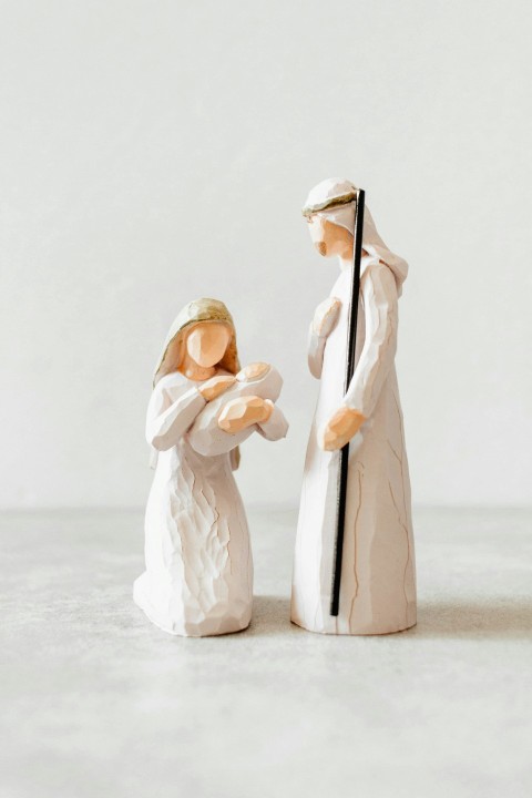 a figurine of a man and a woman holding a cross QP72X