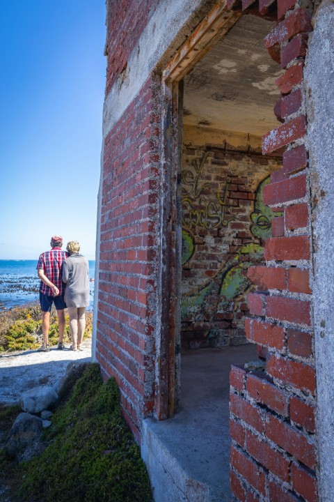 a man and a woman standing outside of a brick building