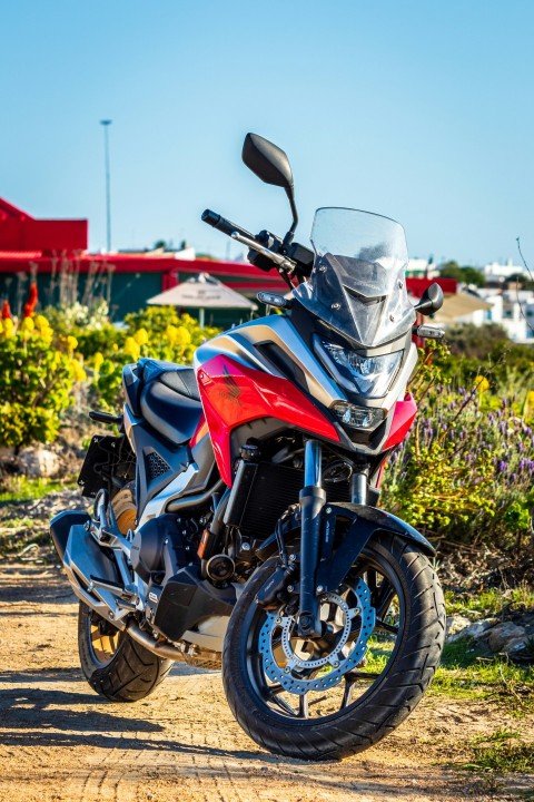 a red and black motorcycle parked on a dirt road