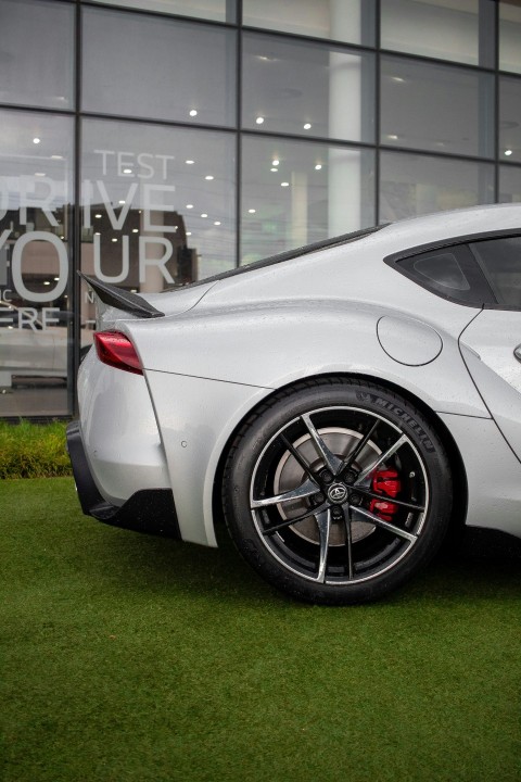 a white sports car parked in front of a building TTdDtg29