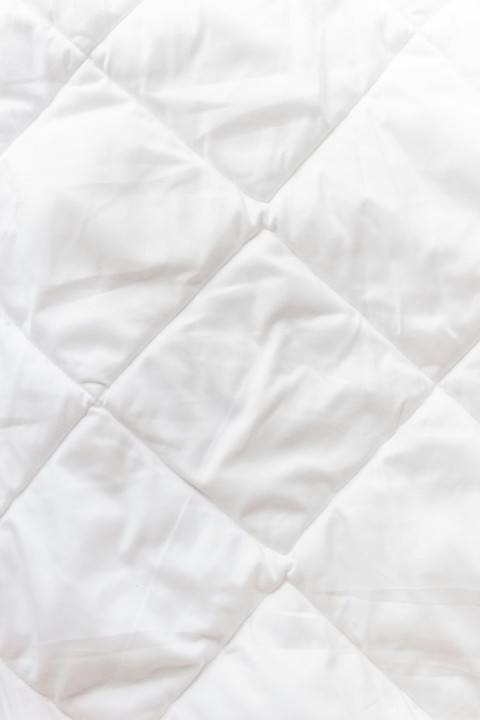 a close up of a white quilted material