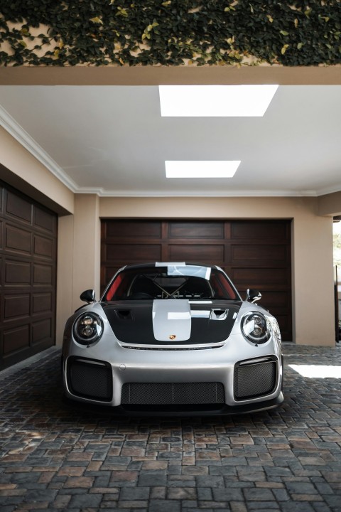 a white and black sports car parked in a garage TLqU