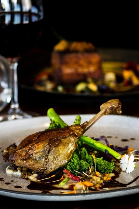 a plate of food on a table with a glass of wine