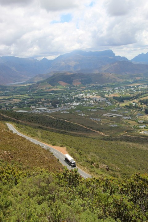 a car driving down a road with mountains in the background