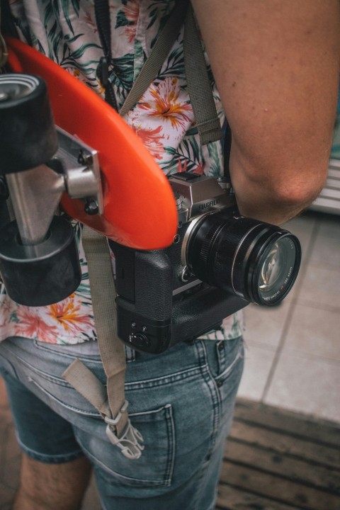 person in blue denim shorts with black dslr camera on lap