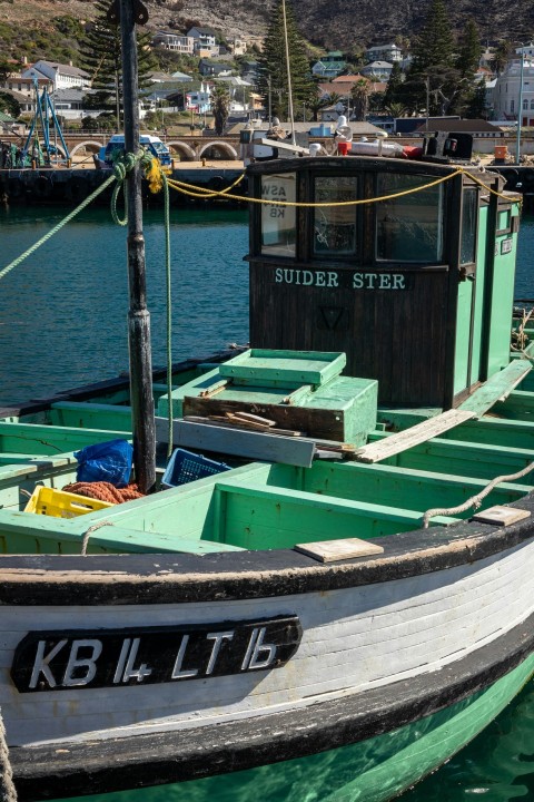 a green and white boat in the water 2hkbw