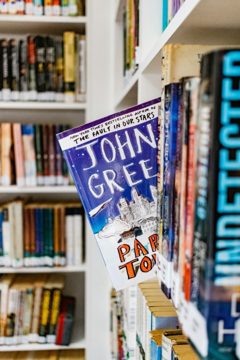 a row of books on a book shelf in a library