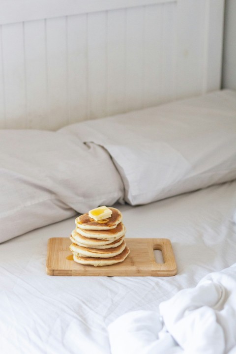 brown wooden tray with cookies on white bed