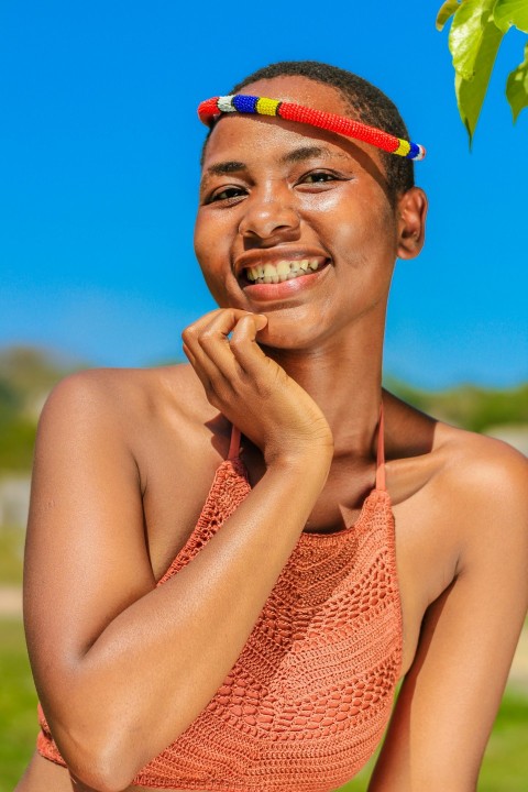 a woman in an orange top is posing for a picture