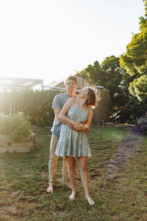 woman in gray dress carrying girl in white dress