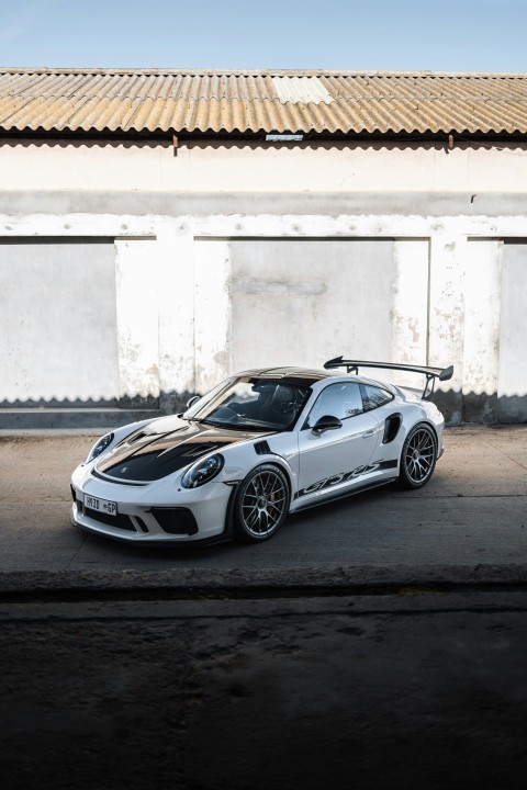 a white sports car parked in front of a building