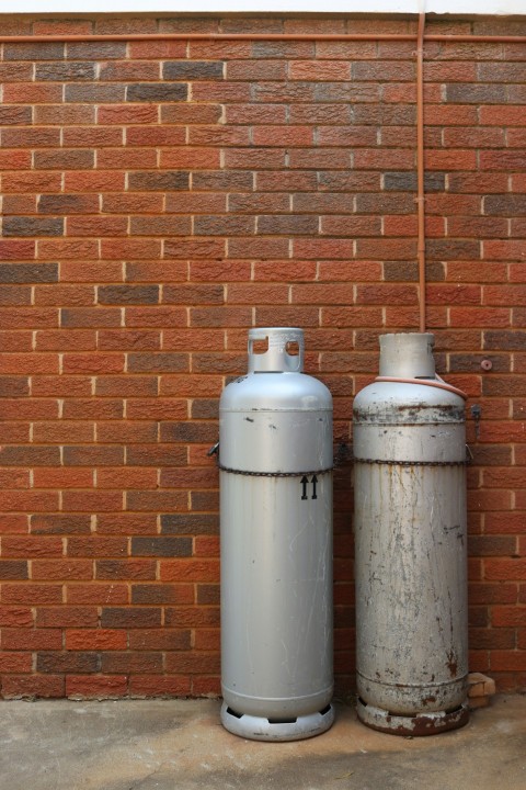 a couple of white bottles next to a brick wall