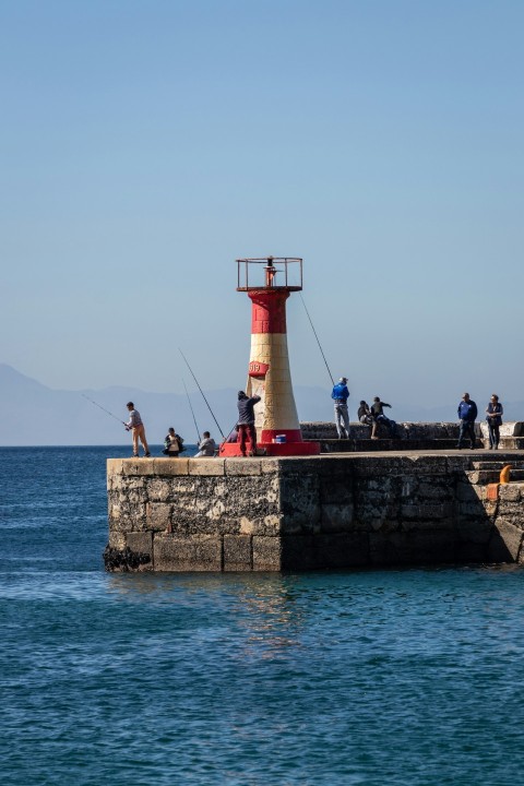 a light house sitting on top of a pier next to the ocean