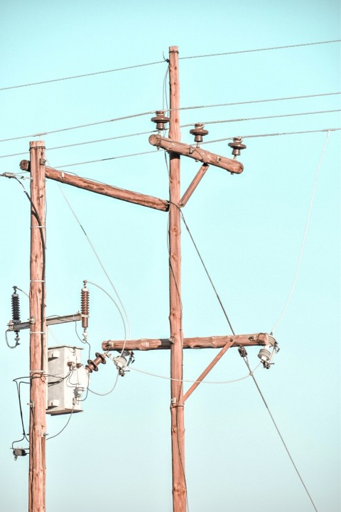 brown electric post under blue sky during daytime