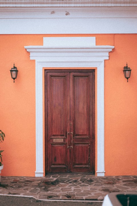 a red and white building with two wooden doors