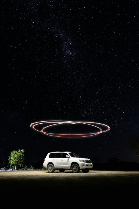 a car parked in front of a red circle in the sky bybllLd5