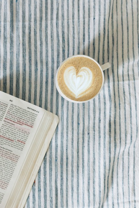 white teacup beside book