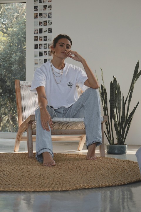 man in white crew neck t shirt sitting on white wooden armchair