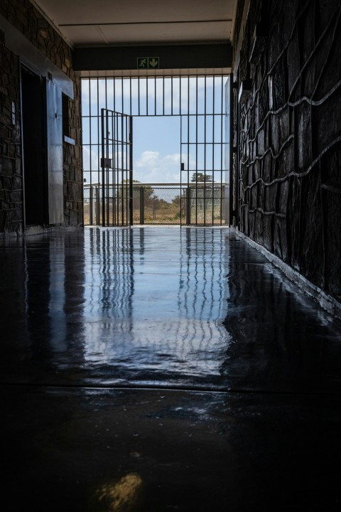 wet hallway leading to an open gate at daytime