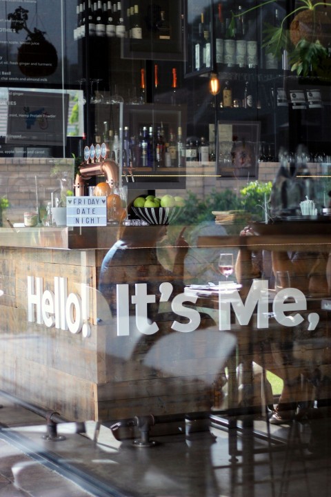 woman in black and white stripe shirt standing in front of glass window