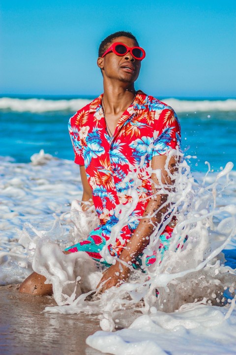 woman in red white and blue floral shirt on beach during daytime zHx8