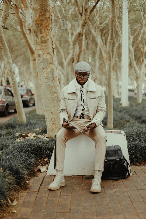 man in white thobe sitting on white plastic box