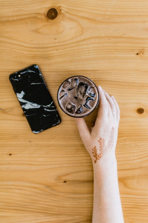 person holding black and silver round container