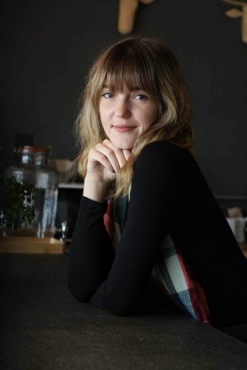 a woman sitting on a counter with her hand on her chin