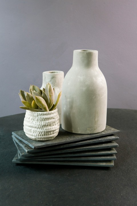 a white vase sitting on top of a black table