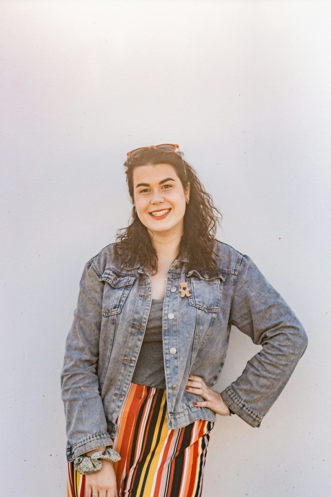 woman in blue denim button up jacket smiling