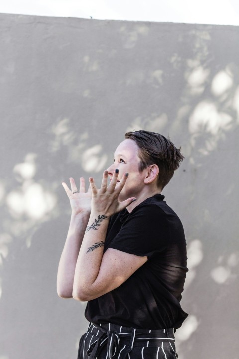 man in black crew neck t shirt covering his face with his hand