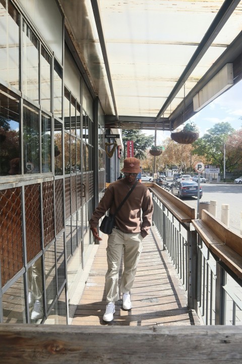 a man walking down a sidewalk next to a building