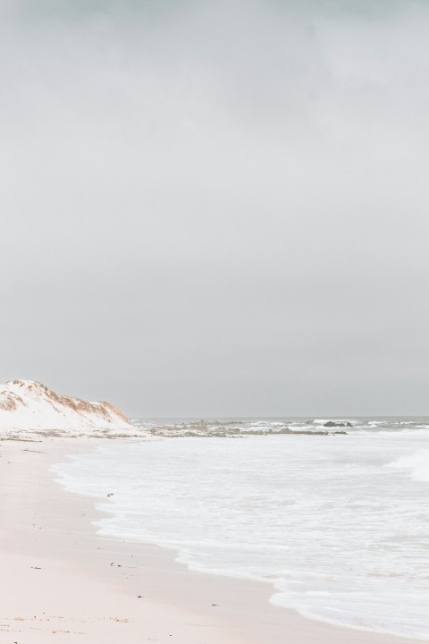 a person walking on a beach with a surfboard