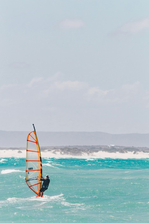 man riding on the black and orange boat photograph