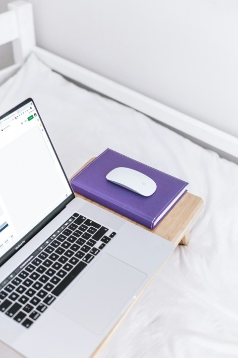 a laptop computer sitting on top of a bed