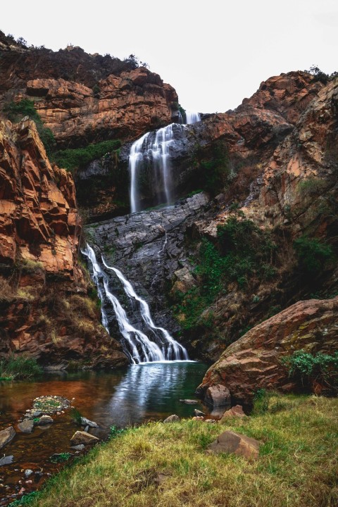 waterfalls between brown rocky mountain during daytime QZp