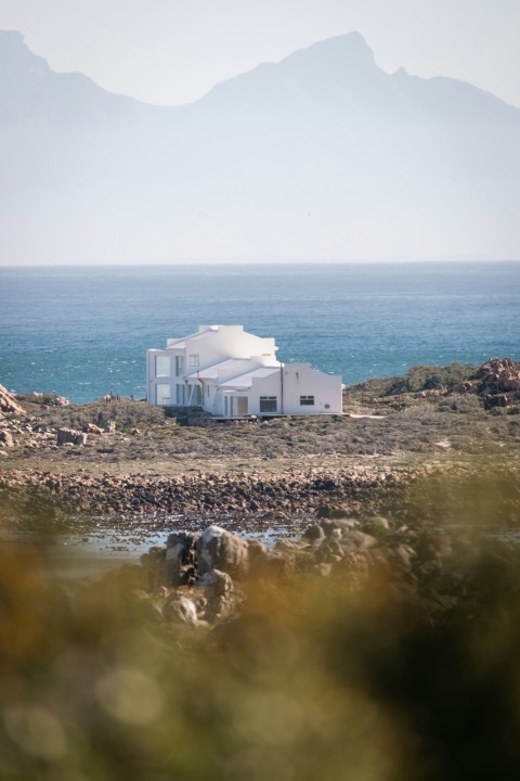 a white house sitting on top of a lush green hillside