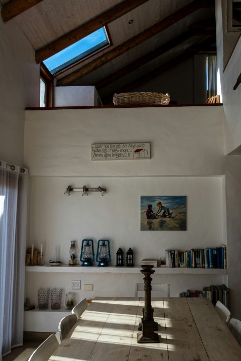 a room with a wooden table and a skylight