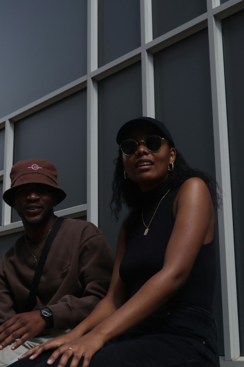 a woman sitting next to a man wearing a hat