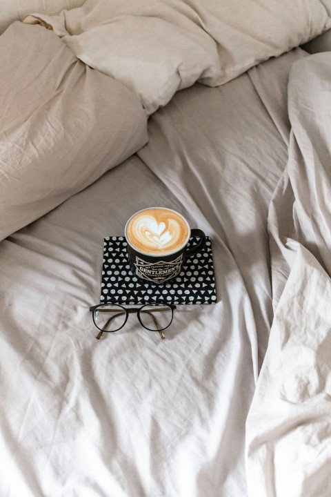 black and white polka dot ceramic mug on black metal tray on white textile sZ