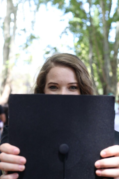 a woman holding up a black piece of paper Q9Fke