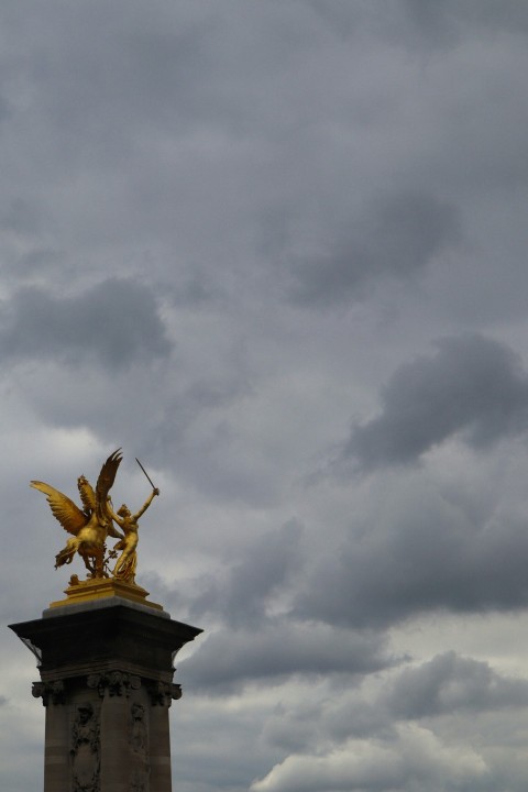 a statue of a winged bird on top of a building