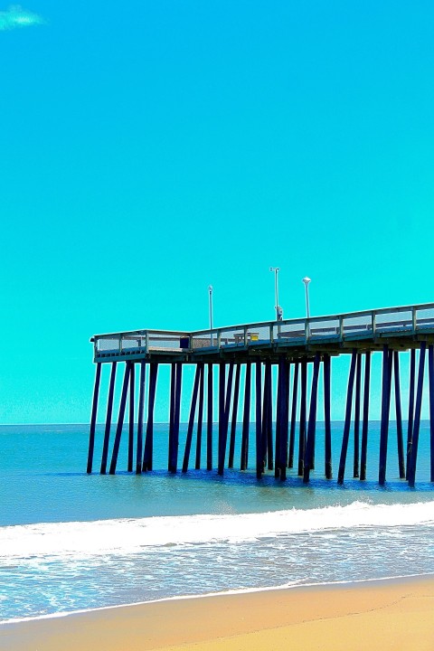 a pier on the beach with the ocean in the background