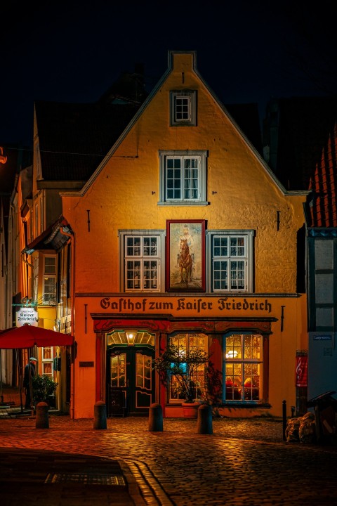 a building with a red awning on a cobblestone street