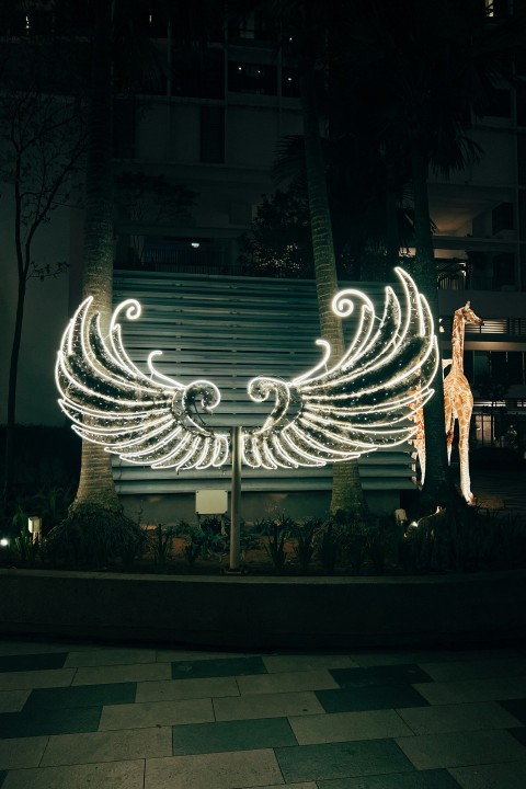 a lighted angel statue in front of a building