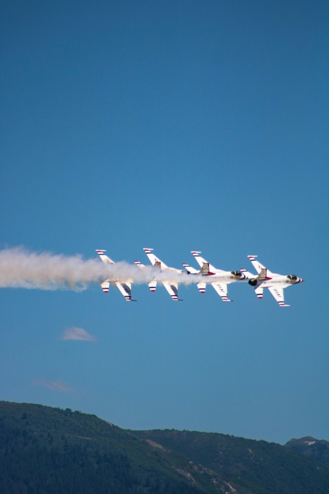 a group of fighter jets flying through a blue sky