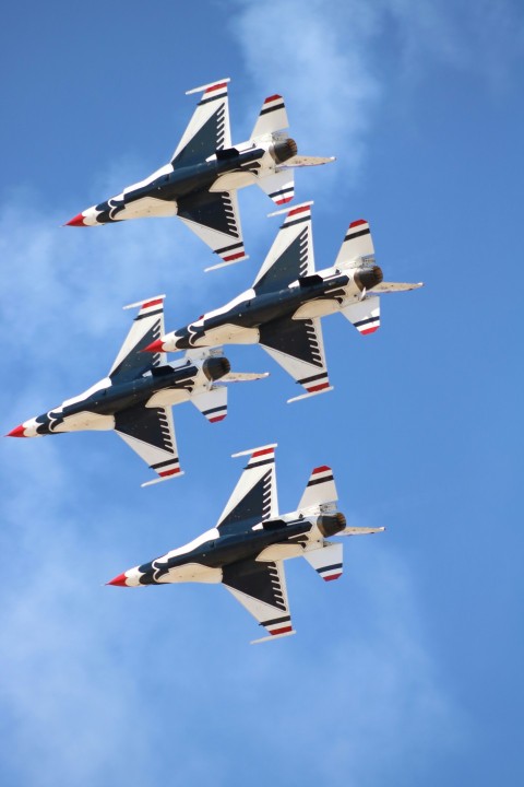 a group of fighter jets flying through a blue sky