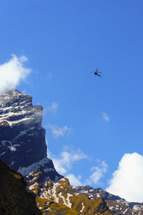 a helicopter is flying over a mountain range