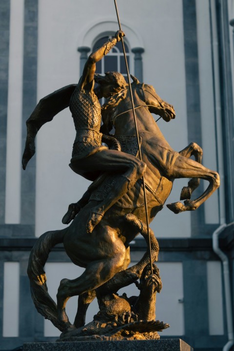 a statue of a man on a horse holding a flag