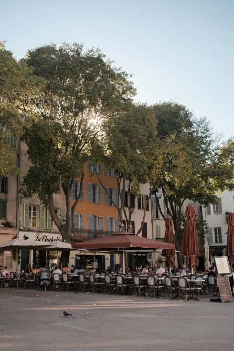 a group of people sitting at tables in front of a building